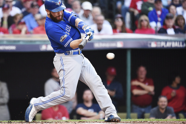 Toronto Blue Jays catcher Russell Martin (55) hits a single against the Cleveland Indians during the second inning of Game 2 of baseball's American League Championship Series in Cleveland, Saturda ...