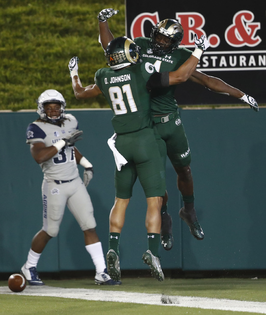 Colorado State wide receiver Michael Gallup, back right, celebrates his touchdown pass reception with wide receiver Olabisi Johnson as Utah State safety Devin Centers looks on in the second half o ...