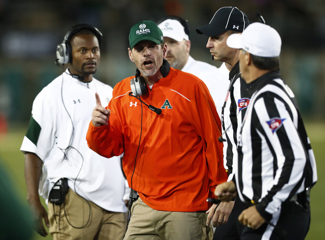 Colorado State head coach Mike Bobo, center, argues for a call with referees while facing Utah State in the second half of an NCAA college football game Saturday, Oct. 8, 2016, in Fort Collins, Co ...