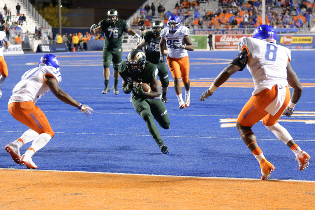 Colorado State running back Dalyn Dawkins runs for a touchdown as Boise State safety Cameron Hartsfield, left, and defensive end Jabril Frazier defend during the second half of an NCAA college foo ...