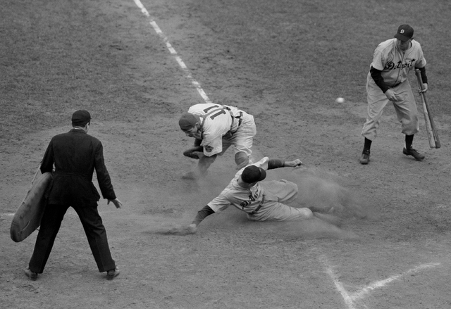 Detroit Tiger second baseman Eddie Mayo slides safely across home plate in the eighth inning of the final World Series game here on Oct. 10, 1945 at Chicago. As Chicago Cubs catcher Mickey Livings ...