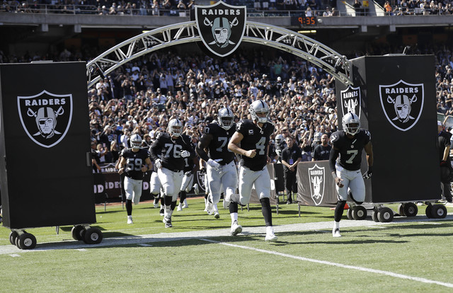Oakland Raiders quarterback Derek Carr (4) and teammates run onto the field before an NFL football game against the San Diego Chargers in Oakland, Calif., Sunday, Oct. 9, 2016. (AP Photo/Marcio Jo ...