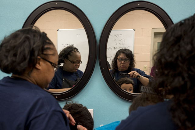 Inmates Kimala Kimble, left, and Candice Austin, right, practice updos on hair mannequins on Thursday, June 30, 2016, at Florence McClure Women's Correctional Center in North Las Vegas. (Bridget ...