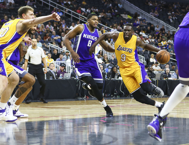 Los Angeles Lakers forward Luol Deng (9) drives past Sacramento Kings forward Rudy Gay (8) during a preseason basketball game at the T-Mobile Arena in Las Vegas on Thursday, Oct. 13, 2016. The Sac ...