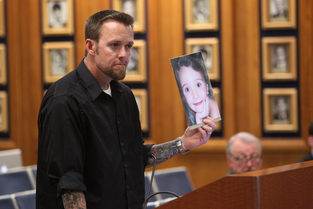 Jason Lamberth speaks to the Clark County School Board March 13, 2014, while holding a photograph of his 13-year-old daughter Hailee Lamberth, who killed herself because of bullying at her school. ...