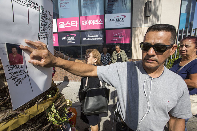 Tomas Hernandez holds a photo of his late sister, Isabel Jimenez Hernandez, who was killed in a gambling tour bus accident, at a makeshift memorial in Los Angeles.  (Damian Dovarganes/The Associat ...