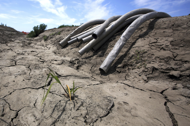 Irrigation pipes sit along a dry irrigation canal on a field near Stockton, Calif., in 2015. (Rich Pedroncelli/The Associated Press)
