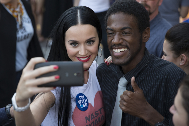 Music artist Katy Perry, left, poses with journalism student Malik Williams after speaking during a campaign rally for Democratic presidential nominee Hillary Clinton at UNLV on Saturday, Oct. 22, ...