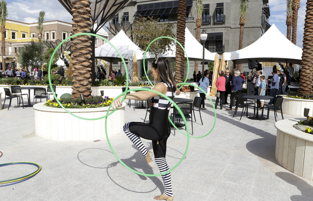 Michelle Bell shows off her circus-style hooping during the ribbon-cutting for the opening of Tivoli Village's second phase Friday, Oct. 28, 2016, in Las Vegas. The second phase added more than 27 ...