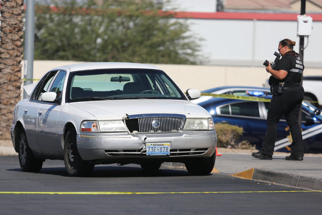 A police investigator takes photos of a sedan outside of a CVS Pharmacy where police arrested the suspect of a shooting on I-15 at the intersection of Las Vegas Boulevard and Windmill Lane in Las  ...