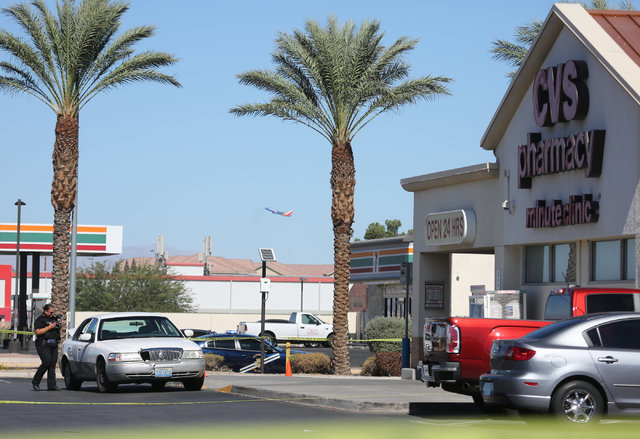 A police investigator takes photos of a sedan outside of a CVS Pharmacy where police arrested the suspect of a shooting on I-15 at the intersection of Las Vegas Boulevard and Windmill Lane in Las  ...