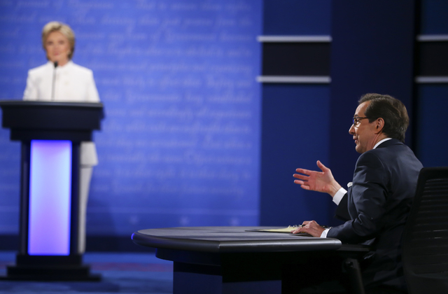Moderator Chris Wallace of Fox News, right, poses a question to Republican presidential candidate Donald Trump, not pictured, and Democratic presidential candidate Hillary Clinton during the third ...
