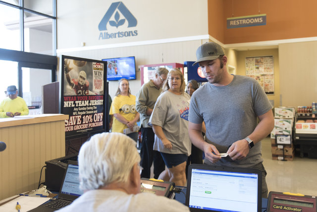 Justin Dahl, right, checks-in during early voting at Albertsons at 2885 E. Desert Inn Rd. in Las Vegas, Saturday, Oct. 22, 2016. Jason Ogulnik/Las Vegas Review-Journal