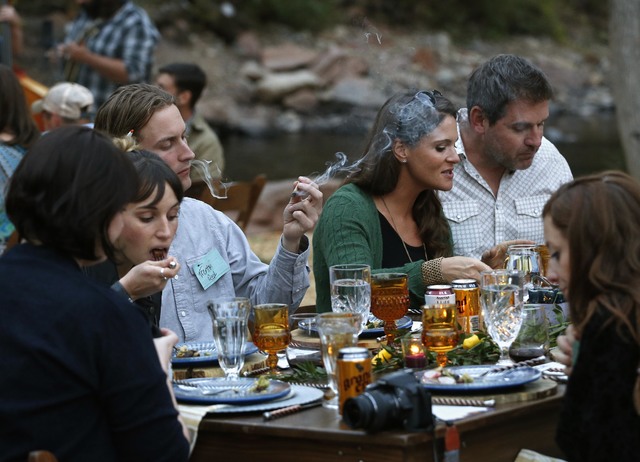 Diners smoke marijuana as they eat dishes prepared by chefs during an evening of pairings of fine food and craft marijuana strains served to invited guests dining at Planet Bluegrass, an outdoor v ...