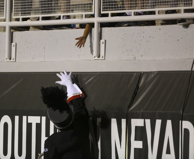 A member of the UNLV band reaches up to a fan during a UNLV football game against Fresno State at Sam Boyd Stadium in Las Vegas on Saturday, Oct. 1, 2016. Miranda Alam/Las Vegas Review-Journal Fol ...