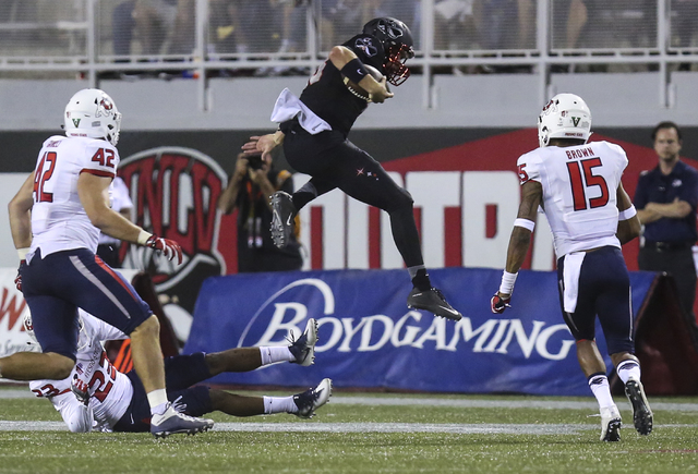 UNLV quarterback Dalton Sneed (18) jumps over Fresno State defensive back Juju Hughes (23) during a football game at Sam Boyd Stadium in Las Vegas on Saturday, Oct. 1, 2016. Miranda Alam/Las Vegas ...