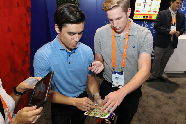 Troy Pettie, left, and Evan Thomas, both UNLV students and Guru Games founders, demonstrate their game Line em Up during Global Gaming Expo Tuesday, Sept. 27, 2016, at the Sands Expo and Conventio ...