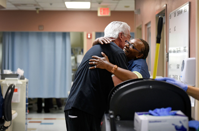University Medical Center Chief of Staff Dr. Dale Carrison, left, greets environmental services worker Theresa McGowan as he begins his morning rounds in the emergency department at at the hospita ...