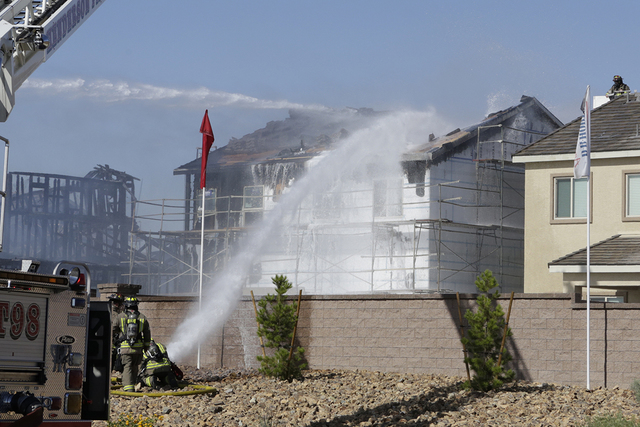Henderson firefighters battle a fire at two under-construction homes in Henderson, near Warm Springs Road and Gibson Road, May 30, 2016. The department added 12 firefighters during a graduation ce ...