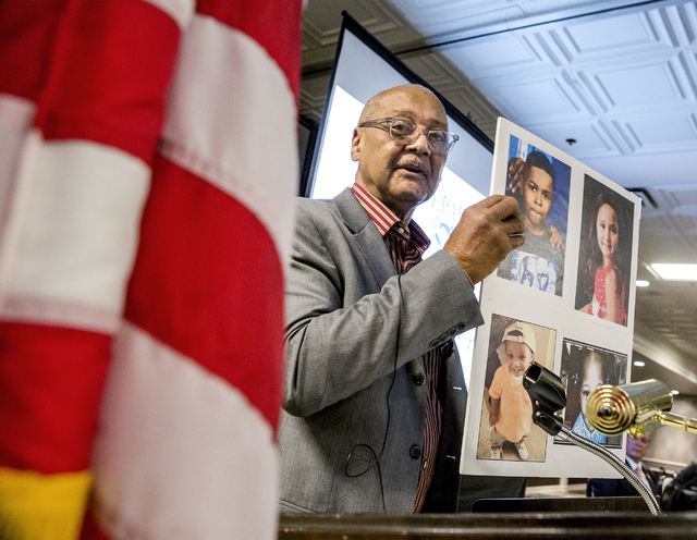 Bob Woodson, founder of the Center for Neighborhood Enterprise in Washington, D.C., holds photos of children who were murdered during the Repairing the Breach summit at Palace Station in Las Vegas ...