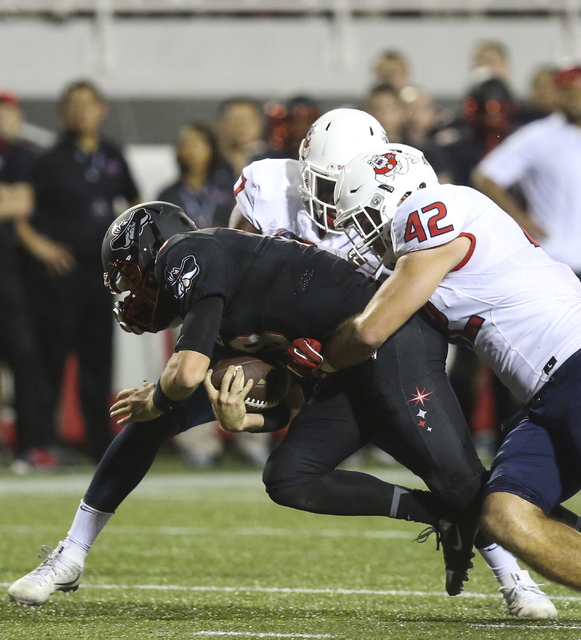 UNLV quarterback Dalton Sneed (18) is tackled by Fresno State defense, including Fresno State linebacker Jeff Camilli (42) and Fresno State linebacker James Bailey (7) during a football game at Sa ...