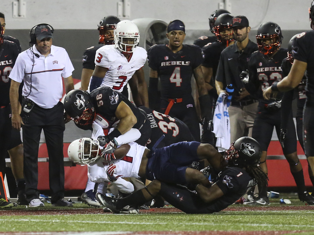 Fresno State wide receiver Jamire Jordan (1) is tackled by UNLV linebacker Ryan McAleenan (56) and UNLV defensive back Jay'Onn Myles (1) during a football game at Sam Boyd Stadium in Las Vegas on  ...