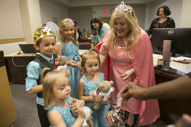 District Court Family Judge Cynthia Giuliani and a courtroom bailiff hand out goodie bags and gifts to Chase, 6, Nevaeh, 3, Jessie, 9, and Leslie, 4, after finalizing the adoption process with the ...