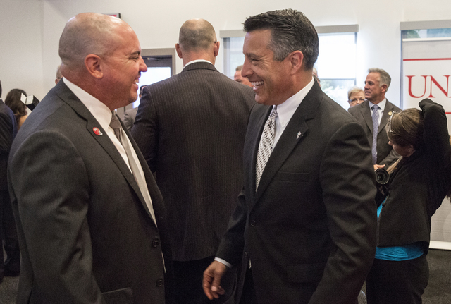 Nevada Gov. Brian Sandoval, right, talks with UNLV head football coach Tony Sanchez at the Richard TAM Alumni Center at UNLV on Monday, Oct. 17, 2016, in Las Vegas. (Benjamin Hager/Las Vegas Revie ...