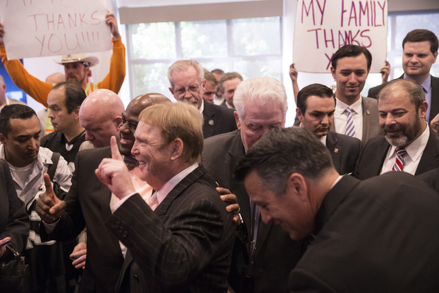 Oakland Raiders owner Mark Davis, left, celebrates with supporters moments after Gov. Brian Sandoval signed Senate Bill 1 at the Richard TAM Alumni Center at UNLV on Monday, Oct. 17, 2016, in Las  ...