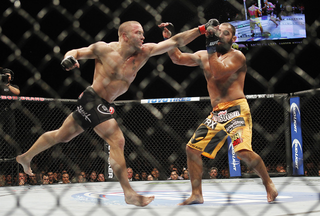 Georges St. Pierre, left, hits Johny Hendricks during UFC 167 at the MGM Grand Garden Arena in Las Vegas on Nov. 16, 2013. (Jason Bean /Las Vegas Review-Journal)