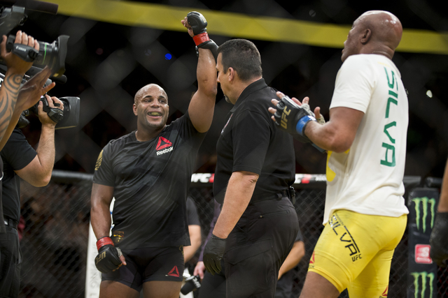 Daniel Cormier, left, raises his arm in victory against Anderson Silva in the light heavyweight bout during UFC 200 at T-Mobile Arena on Saturday, July 9, 2016, in Las Vegas. Cormier won my unanim ...