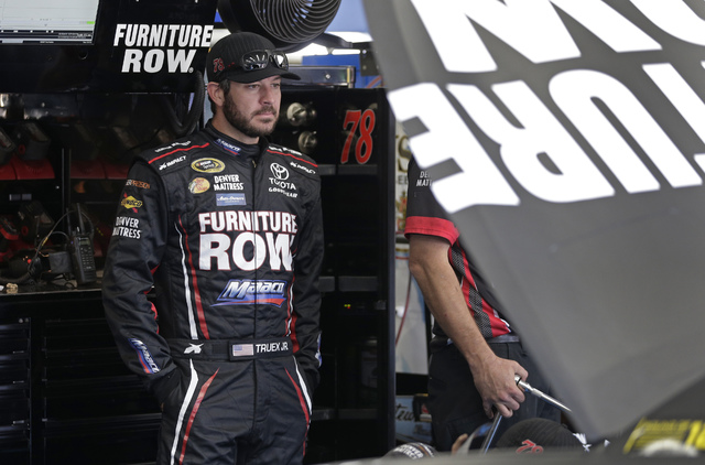 Martin Truex Jr. watches as his crew works on his car before practice for Saturday's NASCAR Sprint Cup series auto race at Charlotte Motor Speedway in Charlotte, N.C., Thursday, Oct. 6, 2016. (AP  ...