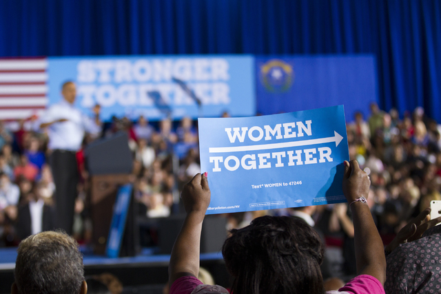 A woman holds up a sign during a speech by President Barack Obama in a campaign rally for Democratic presidential nominee Hillary Clinton at Cheyenne High School on Sunday, Oct. 23, 2016, in North ...