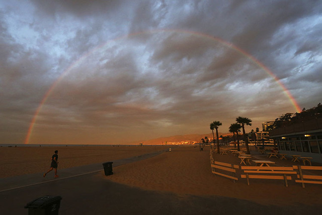 A rainbow appears over the beach and ocean shortly after dawn in Santa Monica, Calif., as one of a series of storms sweeps through California Friday, Oct. 28, 2016. (Reed Saxon/The Associated Press)