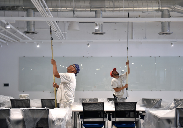 Workers paint as the University of Phoenix's new RedFlint experience center gets ready for it grand opening Monday, Oct. 10, 2016, in downtown Las Vegas. The 11,000 square-foot education campus wi ...