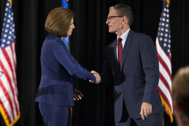 Democratic U.S. Senate candidate Catherine Cortez Masto, shakes hands with U.S. Rep. Joe Heck, R-Nev., after the Nevada Senatorial Debate at Canyon Springs High School on Friday, Oct. 14, 2016, in ...