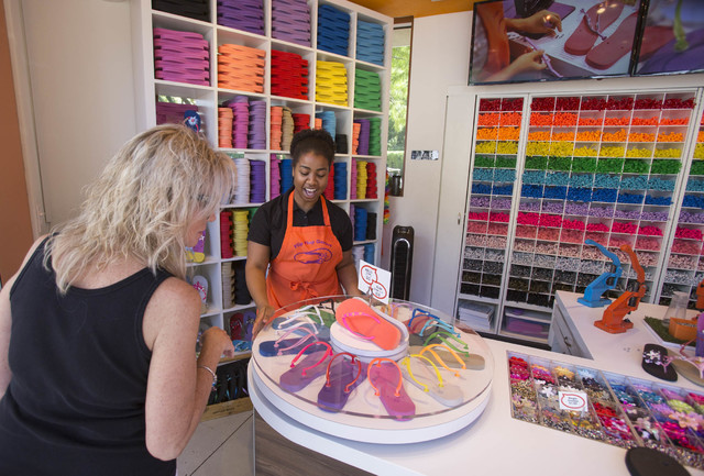 Flip Flop Workshop sales associate Stacie Vance, 22, attends to a browsing customer at the Fashion Show Mall on Tuesday, Oct. 4, 2016. Richard Brian/Las Vegas Review-Journal Follow @vegasphotograph