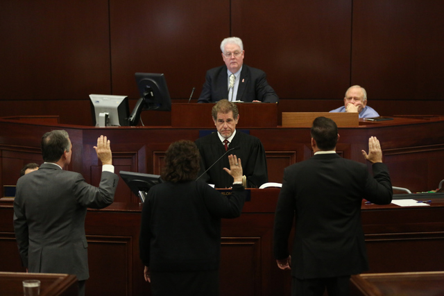 Nevada Supreme Court Justice Ron Parraguirre swears in  Assemblyman Kyle James Stephens, left, Assemblywoman Stephanie Smith, center, and Assemblyman Dominic Brunetti, right, during day one of the ...