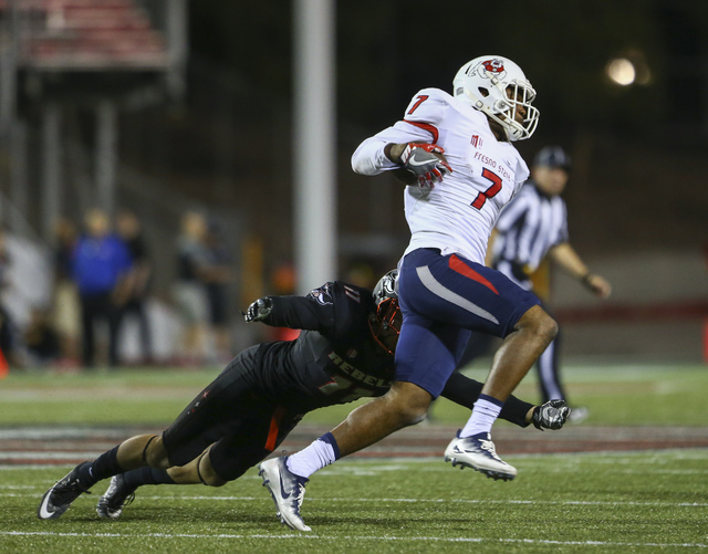 UNLV defensive back Troy Hawthorne (11) looks to tackle Fresno State wide receiver Aaron Peck (7) during a football game at Sam Boyd Stadium in Las Vegas on Saturday, Oct. 1, 2016. UNLV won 45-20 ...
