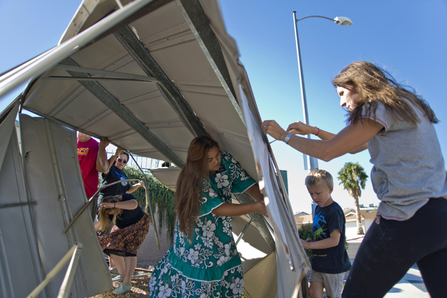 The owners and a group of volunteers help to disassemble a metal shed that blew over a wall and into the parking lot of Horizon Veterinary Clinic in Henderson on Monday, Oct. 17, 2016. (Daniel Cla ...