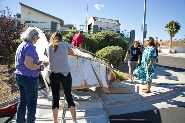 The owners and a group of volunteers help to disassemble a metal shed that blew over a wall and into the parking lot of Horizon Veterinary Clinic in Henderson on Monday, Oct. 17, 2016. (Daniel Cla ...