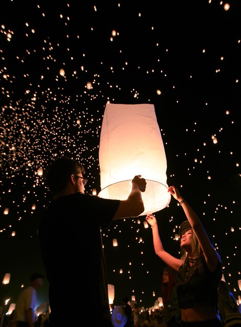 Justin Smith from New York and Trixie Encomienda from Los Angeles release a paper lantern at the RiSE Festival Saturday, Oct. 18, 2014 on a dry lake bed near Jean.  (Sam Morris/Las Vegas Review-Jo ...