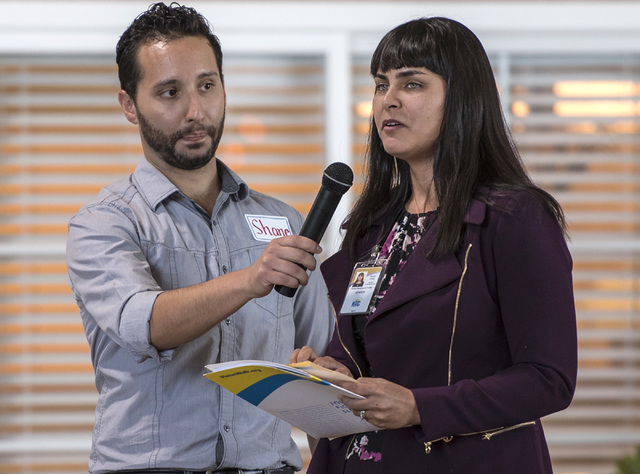Shane Cullen holds a microphone for Raquel O'Neill as she uses brail to read a speech during a Las Vegas Chapter of the Foundation Fighting Blindness meeting at the RTC Mobility Training Center on ...