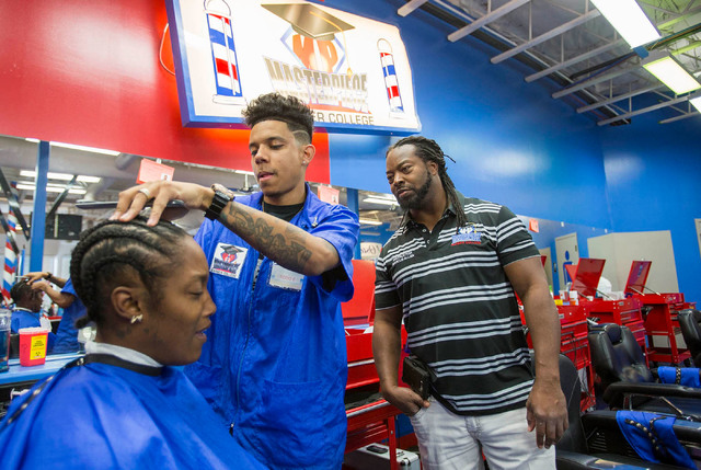 Barber student Todd Elliot, center, fades the hair of customer Keinana Island as instructor Marcus Allen looks on during class at the Masterpiece Barber College in Las Vegas, Thursday, Oct. 20, 20 ...