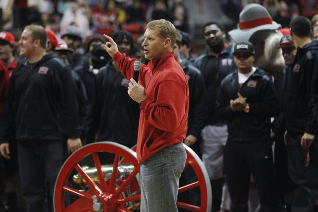 UNLV head football coach Bobby Hauck and the Rebel football team show off the recently won Fremont Cannon as they rally fans for their upcoming bowl game during halftime of the school's basketball ...