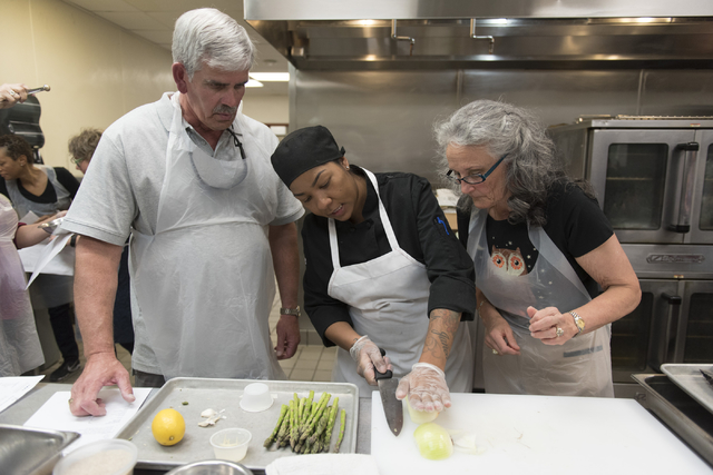 Chef Marisa Rodriguez with the Culinary Academy of Las Vegas, center, assists participants Mary Dickson, right, and Mike Deneff during a cooking class for the Primary Care Cardiometabolic Risk Sum ...