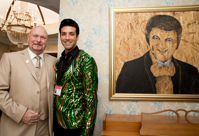 Liberace owner Martyn Ravenhill and Michael Orsini stand next to a painting of Liberace. (Tonya Harvey/Real Estate Millions)
