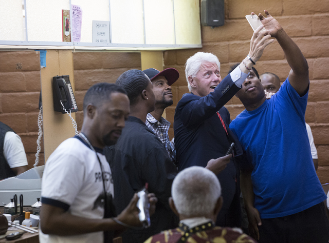 Former President Bill Clinton takes a selfie with D'Mario Osley, right, at Hair Unlimited on Thursday, Nov. 3, 2016, in Las Vegas. President Clinton was in Las Vegas for a rally at Cox Pavilion fo ...
