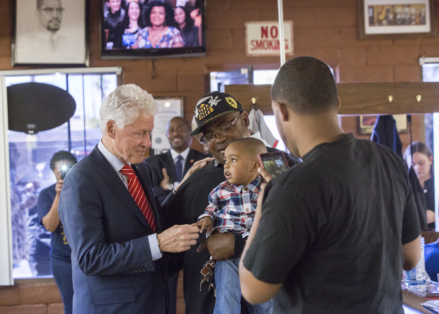 Former President Bill Clinton shakes hands with Christian Smith, 2, at Hair Unlimited on Thursday, Nov. 3, 2016, in Las Vegas. President Clinton was in Las Vegas for a rally at Cox Pavilion for hi ...