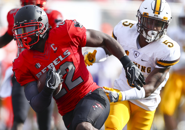 UNLV running back David Greene (22) runs the ball to score a touchdown as Wyoming cornerback Rico Gafford (5) defends during a football game at Sam Boyd Stadium in Las Vegas on Saturday, Nov. 12, ...
